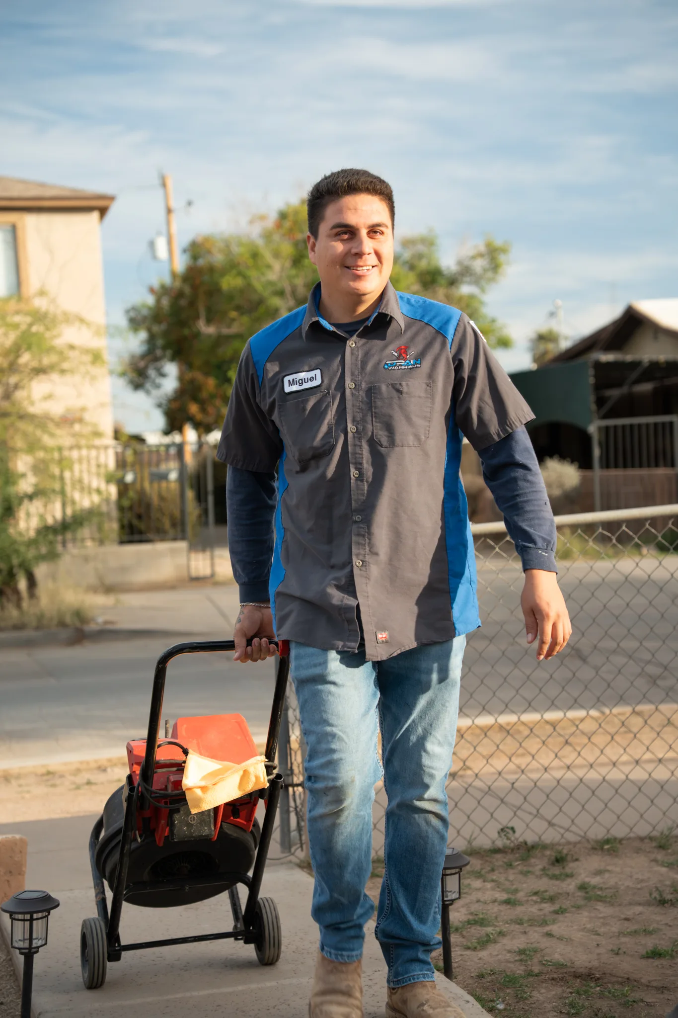 Warriors Plumbing & Rooter technician arriving at a Phoenix home with a drain machine